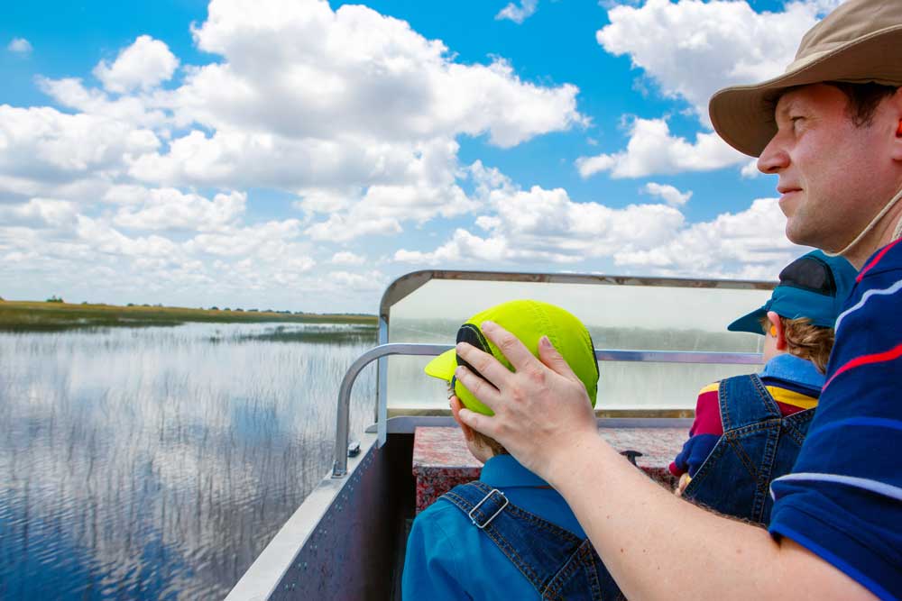 A father and his two young sons enjoy an airboat tour through the Florida wetlands of Everglades National Park. Irina Wilhau