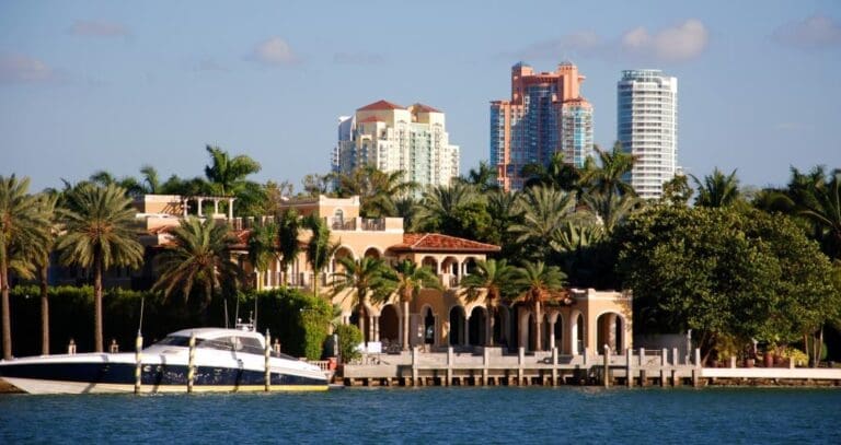 A yacht docked at a luxury property on Star Island with South Beach's Portofino Tower in the background