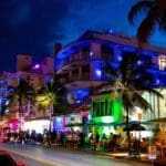 Ocean Drive illuminated by its iconic neon lights at night.