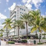 Breathtaking view of the Victor South Beach Hotel from across Lummus Park and Ocean Drive.