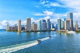 View of Miami's cityscape with motorboats navigating the waters of Biscayne Bay near downtown.
