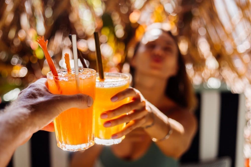 A couple raising their cocktails in a toast at Broken Shaker.