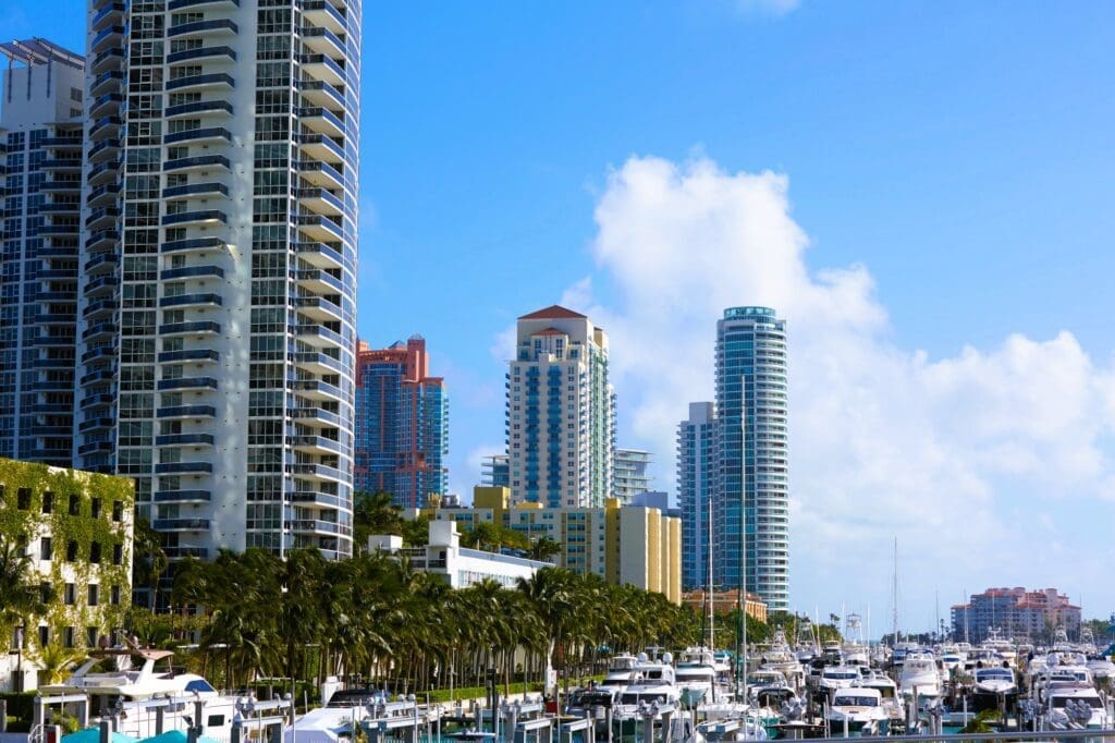 Beautiful view of boats and yachts docked at the Miami Beach Marina from MacArthur Causeway, with the upscale buildings of South Beach in the background