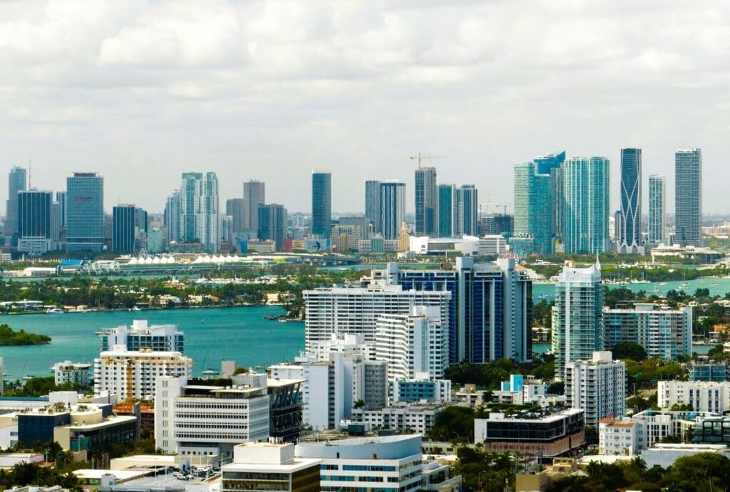 Aerial view of Miami's downtown office district on a bright, sunny day, showcasing towering commercial and residential skyscrapers