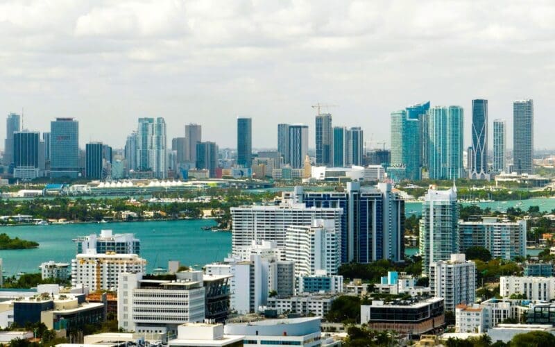 Aerial view of Miami's downtown office district on a bright, sunny day, showcasing towering commercial and residential skyscrapers