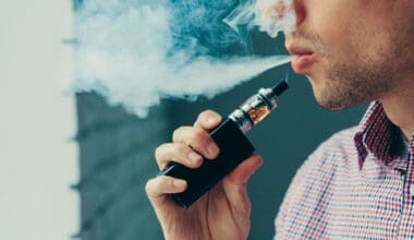 A man takes a deep breath and exhales a cloud of vapor from his electronic cigarette