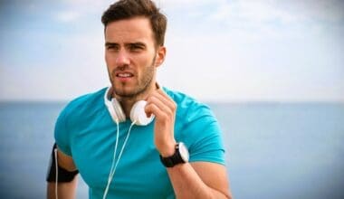 Close-up of a young, fit man jogging along the shoreline