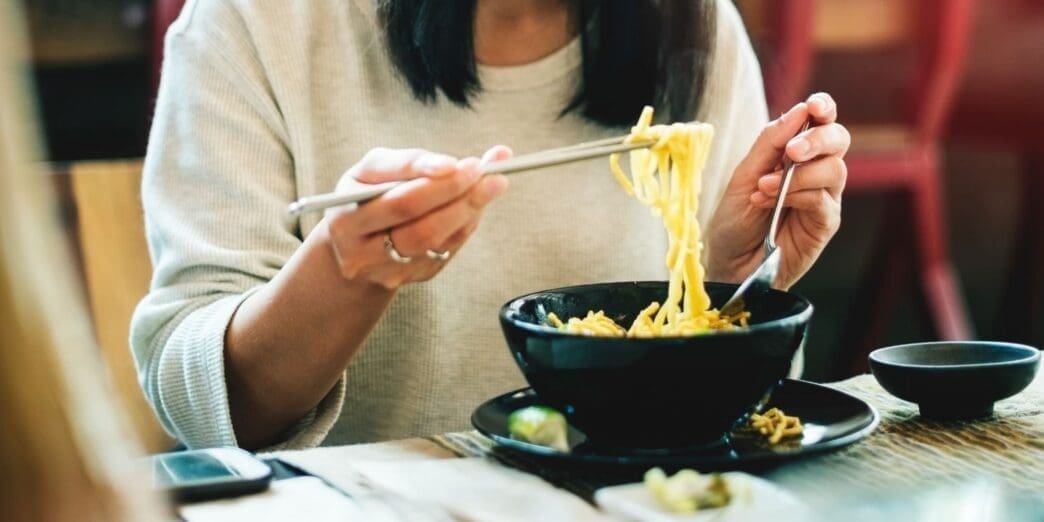Close-up of an Asian woman eating noodles