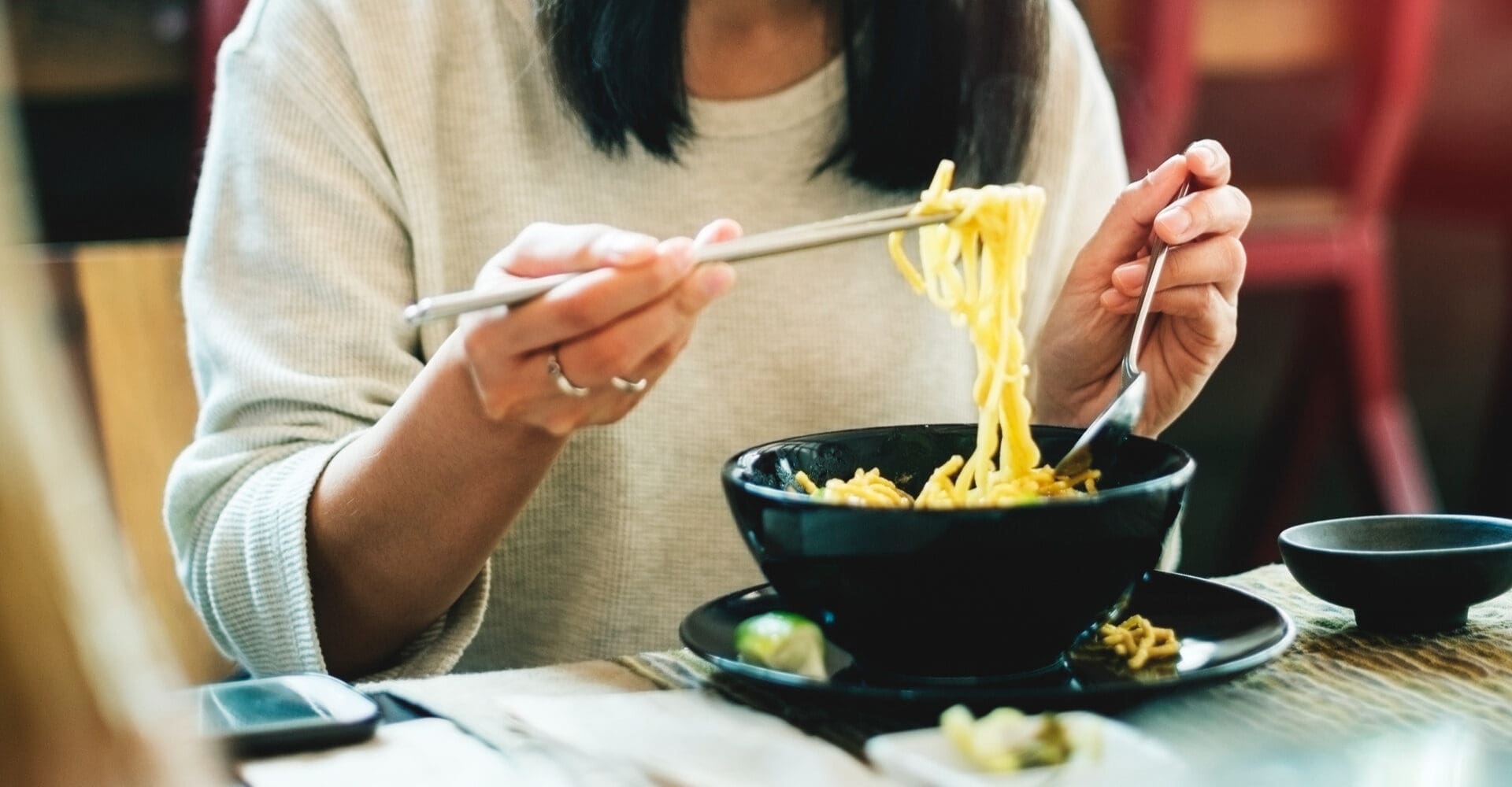 Close-up of an Asian woman eating noodles