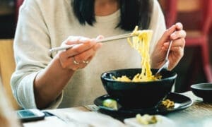 Close-up of an Asian woman eating noodles