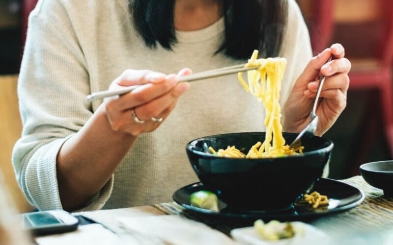 Close-up of an Asian woman eating noodles