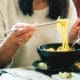 Close-up of an Asian woman eating noodles