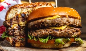 Side view of a double cheeseburger with beef patties, cheese, and lettuce