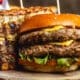 Side view of a double cheeseburger with beef patties, cheese, and lettuce