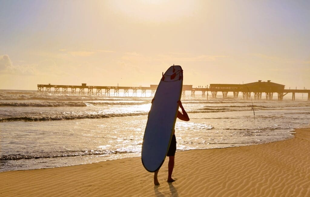 Surfer at Sunset on Daytona Beach, Florida, with Pier in the Background