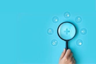 A hand holding a magnifying glass represents a focus on healthcare and medical concepts, symbolizing the importance of access to advanced medical technology and welfare services.