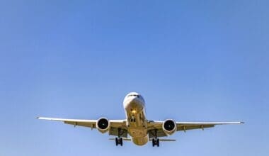 A low-angle shot of an airplane soaring overhead during the day