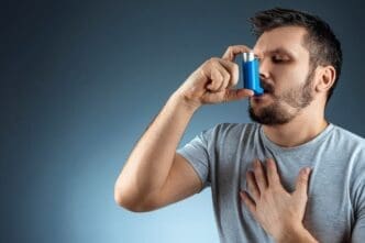 A portrait of a man gripping his asthma inhaler, experiencing an asthmatic attack.
