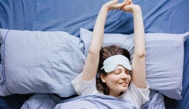 A young woman awakens in bed, feeling refreshed after a peaceful night’s sleep.