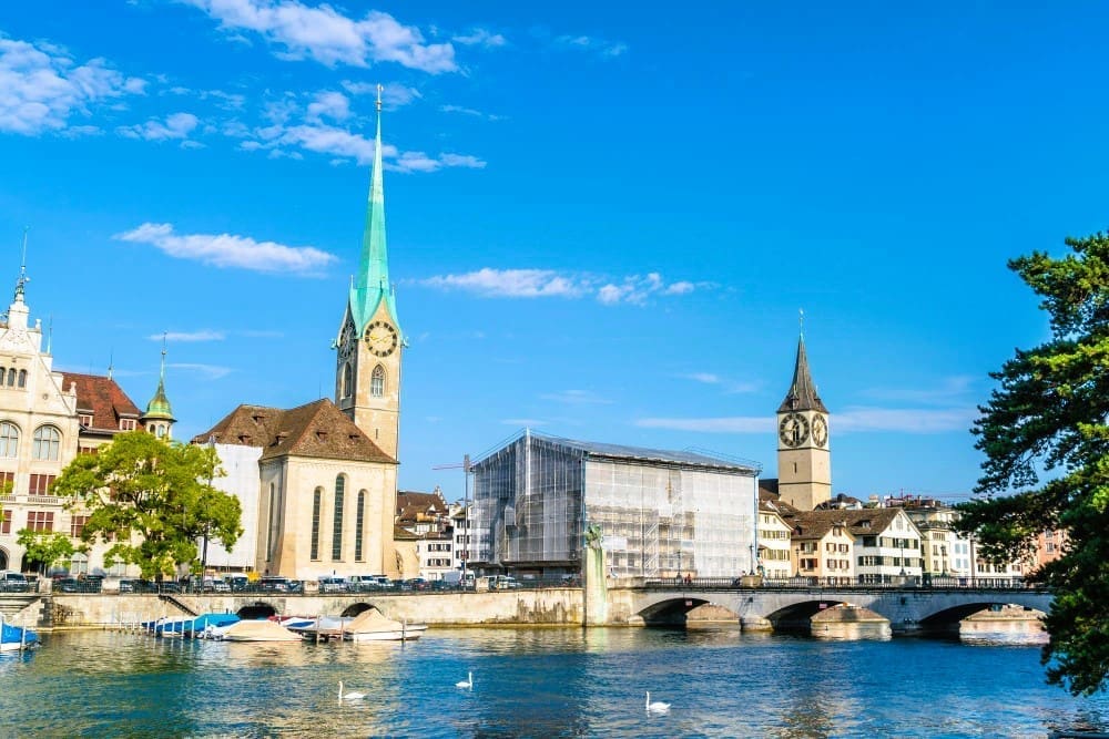 Arch bridge spanning the river amidst the buildings in Zurich, Switzerland