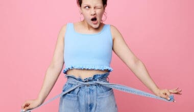 Close-up of a funny girl making a grimace, showcasing her emotions about weight loss while posing with earrings—authentic lifestyle moment.