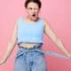 Close-up of a funny girl making a grimace, showcasing her emotions about weight loss while posing with earrings—authentic lifestyle moment.