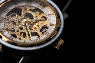 Close-up of a luxurious gold clock displaying a time adjustment