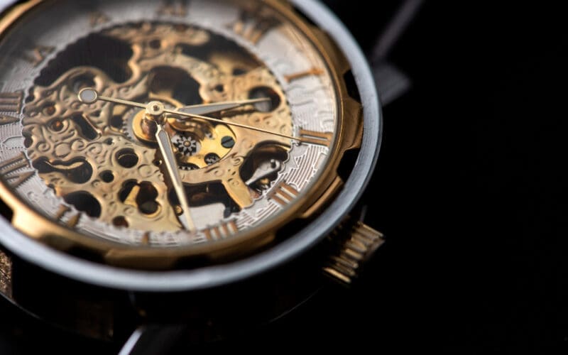 Close-up of a luxurious gold clock displaying a time adjustment