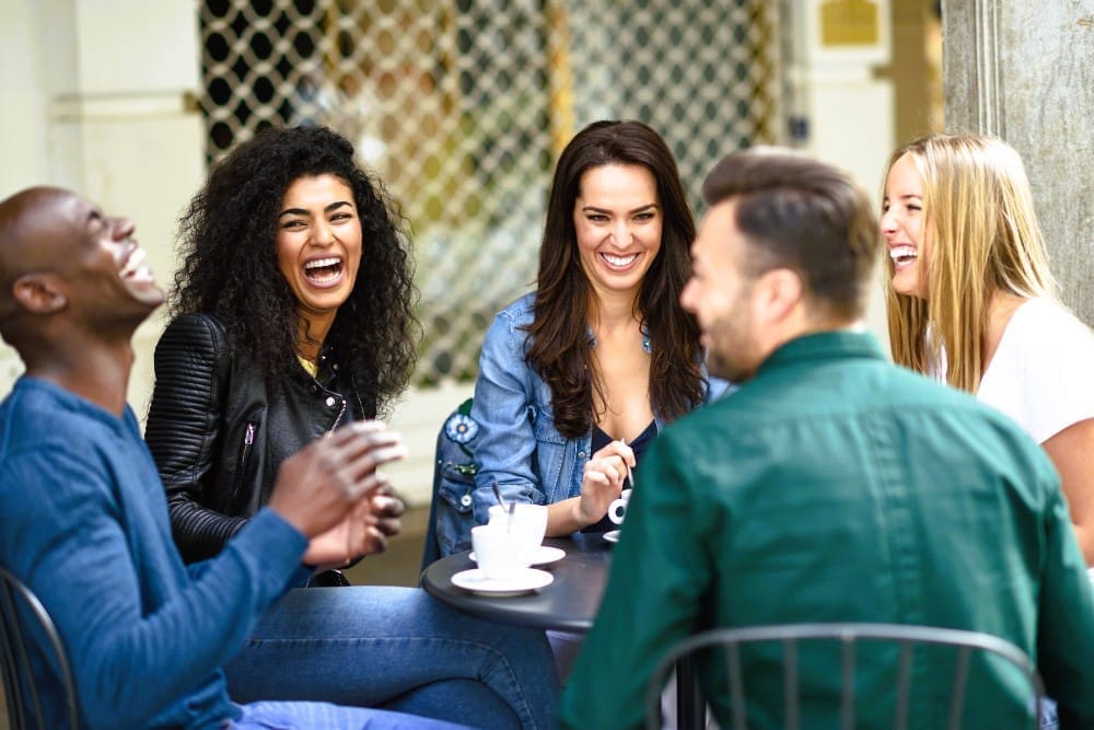 Diverse group of five friends enjoying coffee together