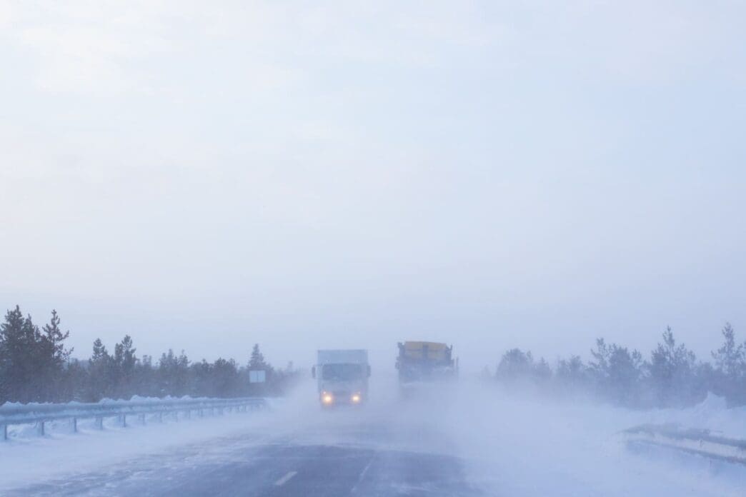 Highway featuring trucks navigating through severe winter weather