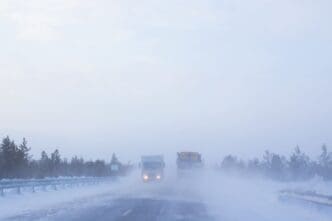 Highway featuring trucks navigating through severe winter weather