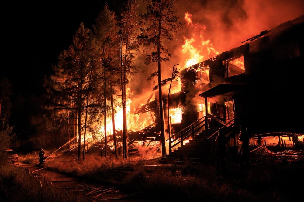 Houses ablaze at night during a wildfire