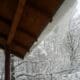 Low-angle view of the roof with snow-covered trees in the yard