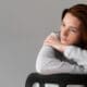 Medium shot of a woman sitting in a chair, looking visibly depressed