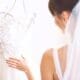 The elegant bride delicately drapes her white wedding gown in her room