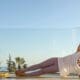 Young woman wearing headphones exercising at home