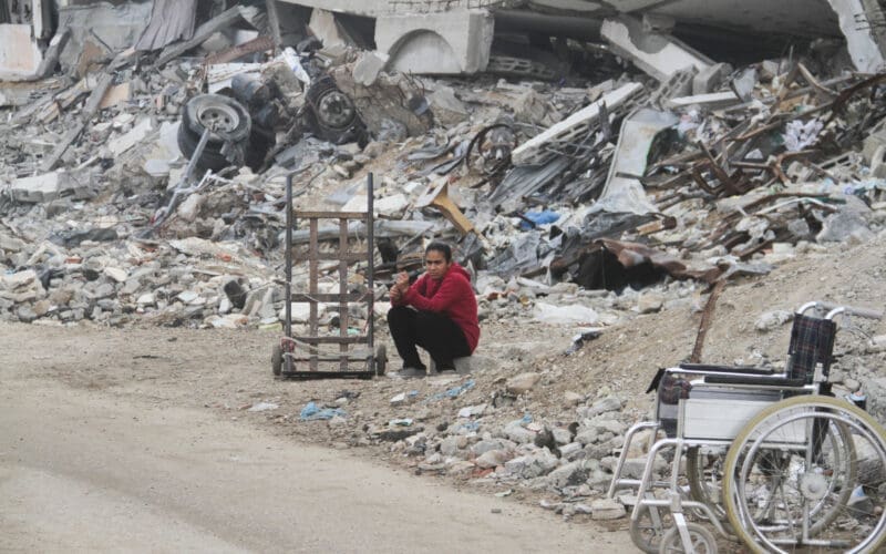 A Palestinian girl sits by the rubble of buildings destroyed in previous Israeli strikes, ahead of a ceasefire set to take effect on Sunday, in Gaza City