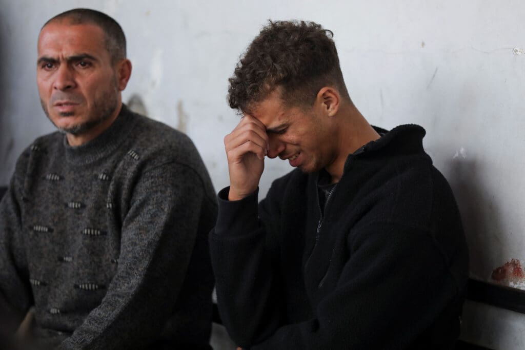 People mourn near the bodies of Palestinians killed in Israeli strikes, in Gaza City