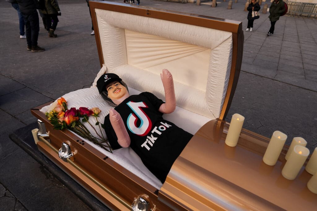 Coffin containing a blow up doll, dressed in TikTok merch is used by comic Zach Sage, who posts content on TikTok, as he films in Washington Square Park in New York City