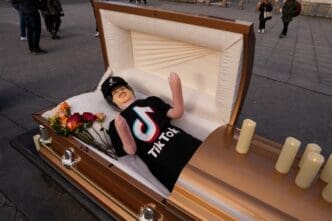 Coffin containing a blow up doll, dressed in TikTok merch is used by comic Zach Sage, who posts content on TikTok, as he films in Washington Square Park in New York City