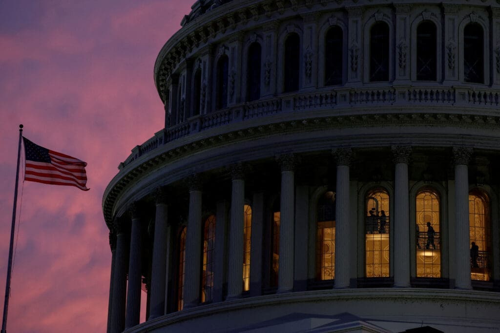 People walk inside the upper floors of the rotunda of the U.S. Capitol building at sunset in Washington
