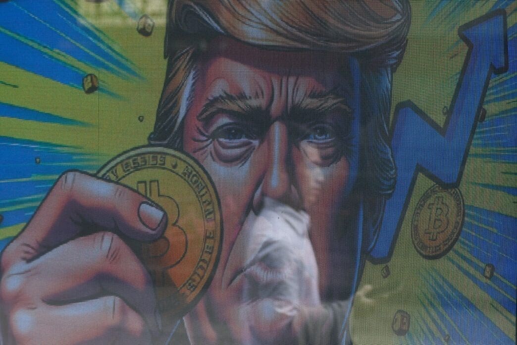 An illustration featuring U.S. President-elect Donald Trump holding Bitcoin is displayed outside a cryptocurrency exchange store after Bitcoin soars above $100,000, in Hong Kong