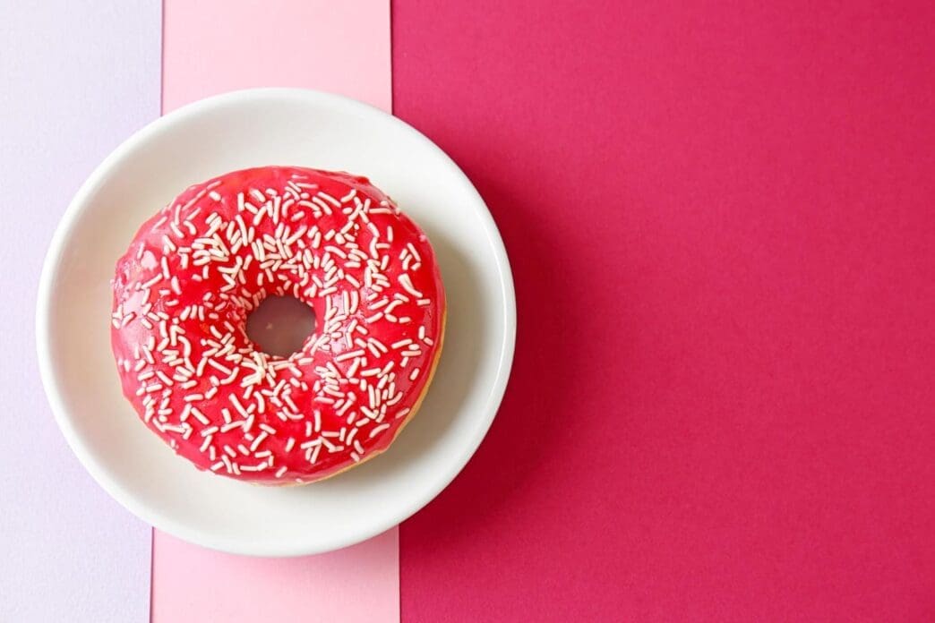 A plate featuring a delectable red donut