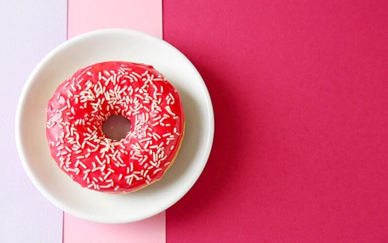 A plate featuring a delectable red donut