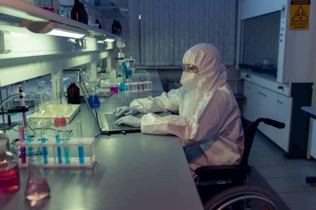 A female researcher in protective gear is working in a laboratory, studying rare illnesses