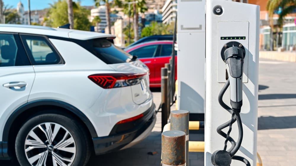 A hybrid vehicle charging at a charging station