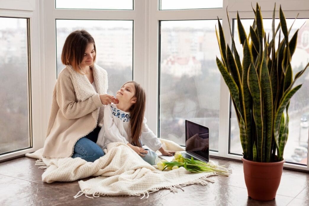 A mother and daughter sitting together on the floor at home