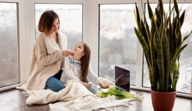 A mother and daughter sitting together on the floor at home