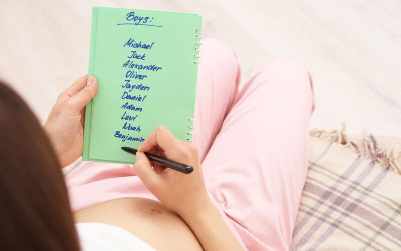 A pregnant woman is at home reviewing a list of names