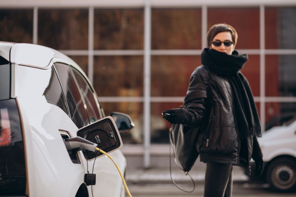 A woman charging her electric car on the street